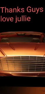 Copper colored luxury car with personalized message on wallpaper.