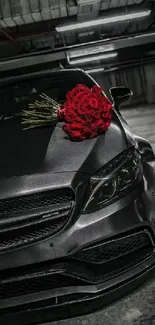 Sleek black luxury car with red roses bouquet on hood.