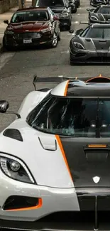 Luxury cars lined up on a city street.