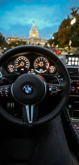 Luxury car steering wheel with cityscape in view.