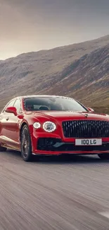 Luxurious red car on a scenic mountain road, mobile wallpaper.