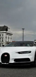 White sports car on urban street with buildings.