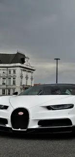 Luxury sports car on urban street with dramatic sky.