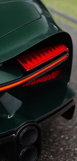 Close-up of a sleek car tail light with a dark green finish and red accents.