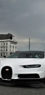 Sleek white sports car with grey sky background.