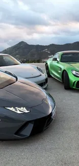 Three luxury sports cars in a mountain view setting.