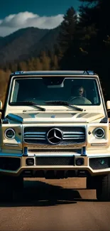 Luxury SUV driving on mountain road with scenic backdrop.