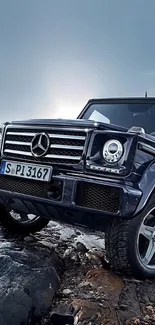 Luxury SUV on rocky terrain with cloudy sky backdrop.