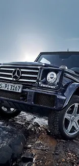 Luxury Mercedes SUV on rocky terrain under a cloudy sky, showcasing rugged elegance.