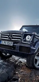 Luxury SUV on rocky terrain with dark blue sky background.