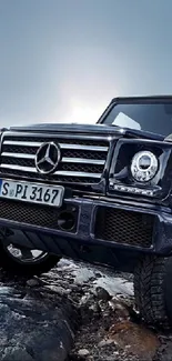 Luxury Mercedes SUV on rocky terrain basking under a moody sky.