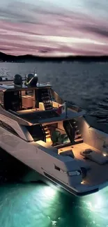 A luxury yacht illuminated under a stunning sunset sky.