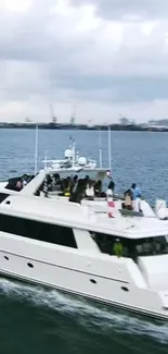 Luxury yacht cruising on open sea with a skyline in the background.