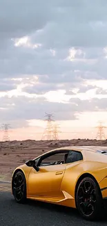 Yellow luxury sports car on desert road under cloudy skies.