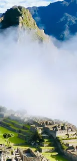 Machu Picchu shrouded in mist with mountain backdrop.