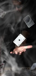 Dark wallpaper with floating playing cards and a hand.