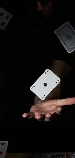 Hand and playing cards in magic trick wallpaper.