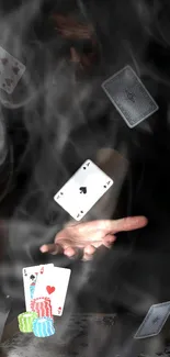 Hand performing magic with floating playing cards in smoke.