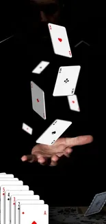 Floating playing cards on black backdrop.