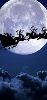 Santa's sleigh silhouetted against full moon in midnight blue sky.