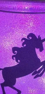 Magical unicorn silhouette on a purple glowing background.