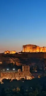 The Acropolis illuminated at twilight set against a vibrant blue sky.