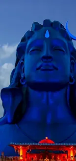 Majestic blue Shiva statue under a vibrant sky in mobile wallpaper.