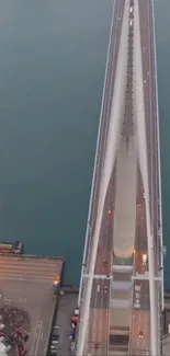 Aerial view of bridge over blue waters at sunset.