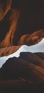 Majestic canyon with dark brown rock formations under open sky.