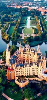 Aerial view of a majestic castle surrounded by lush greenery and water.