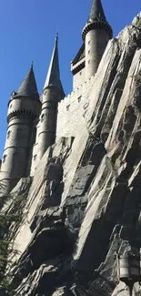 Majestic stone castle with tall turrets under a clear blue sky.