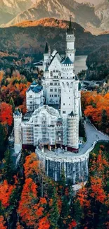 Majestic castle surrounded by autumn foliage with mountains in the backdrop.