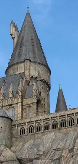 Stone castle with tall turrets under a clear blue sky.