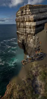 Majestic cliff over a calm ocean with dramatic sky.