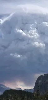 Dramatic clouds tower above a mountain landscape.