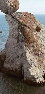 A breathtaking view of a unique coastal rock formation by the serene ocean.