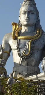 Majestic deity statue with intricate details in gray and gold tones.