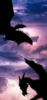 Silhouette of dragons in a stormy purple sky with lightning.