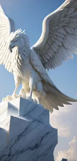 Majestic eagle statue on marble pedestal against blue sky.