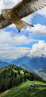 Falcon soaring over green mountains and blue sky with clouds.