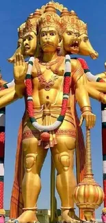 Golden five-headed idol against a blue sky.