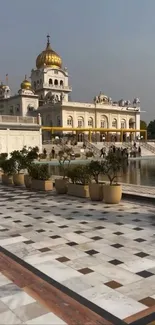 A majestic temple with golden domes reflected in a serene pond.