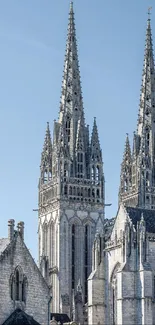 Gothic cathedral spires under blue sky.