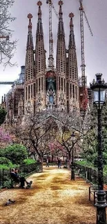 Stunning view of Sagrada Familia with lush park foreground and cloudy sky.