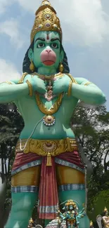 Statue of Hanuman set in a green landscape.