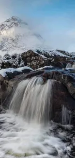 Majestic Highland waterfall with snowy mountains backdrop.