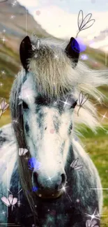 Grey horse standing in a lush green meadow with mountain backdrop.