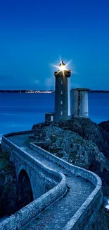 Majestic lighthouse overlooking ocean at twilight with rocky path.
