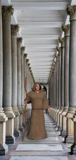 Monk standing in a grand monastery corridor with tall columns.