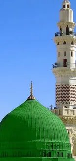A stunning green mosque dome with minaret against blue sky.